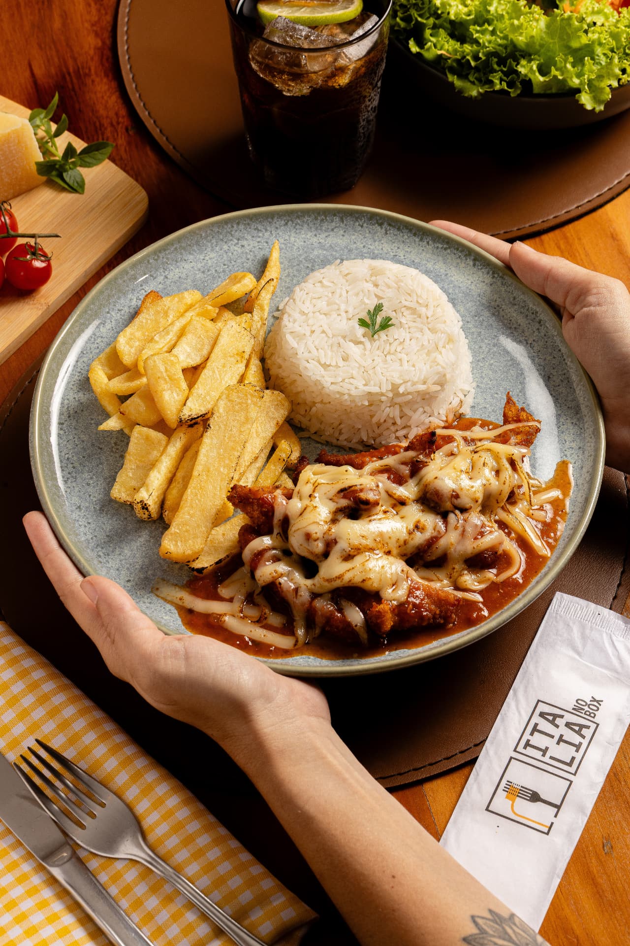 Parmegiana servida com arroz e batatas
